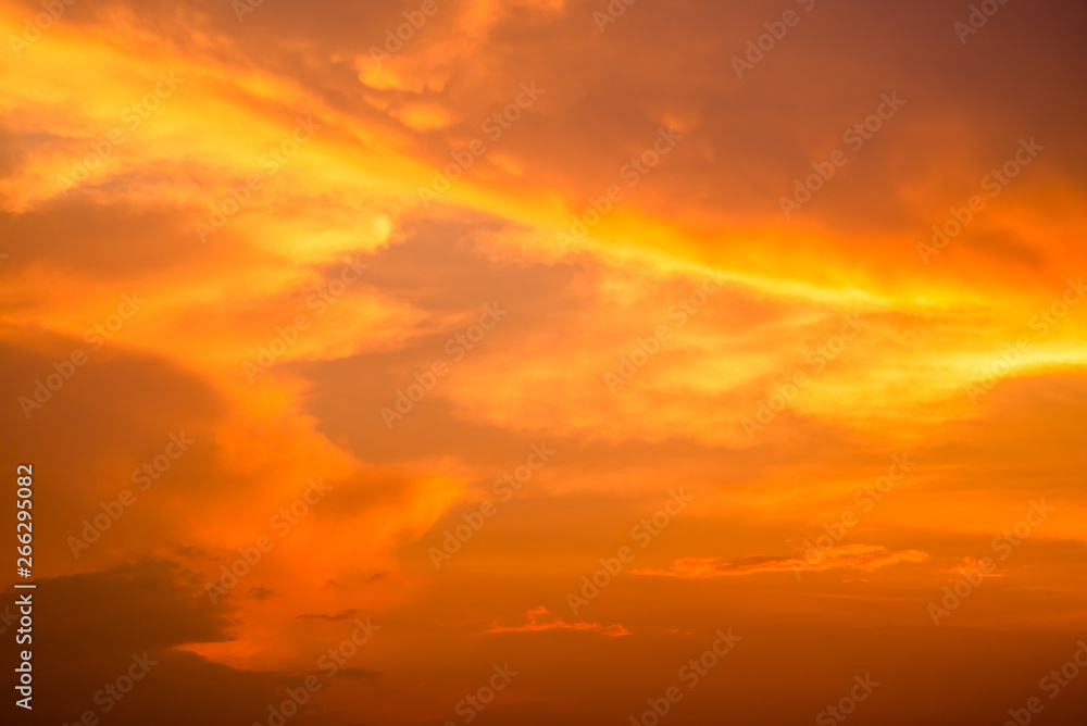 Cloudy sky and orange light of the sun through the clouds