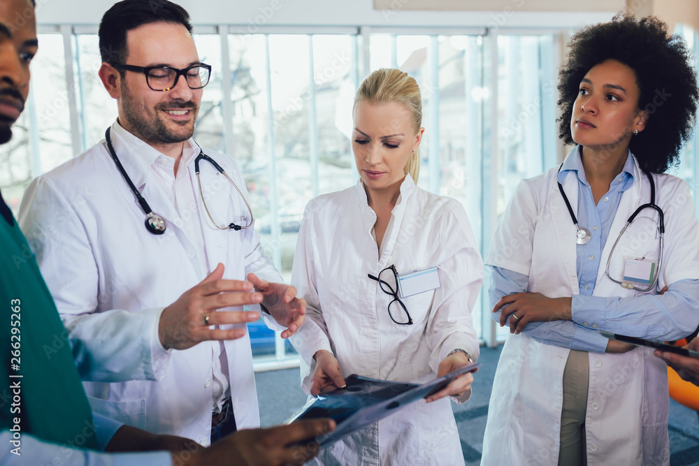 Doctor holding up an x-ray with fellow doctors Doctor holding up an x-ray with fellow doctors
