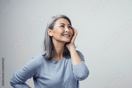 Side profile of charming asian woman smiling on white background