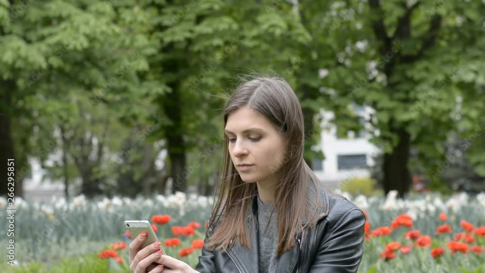 attractive girl writes sms in the park attractive girl writes sms in the park