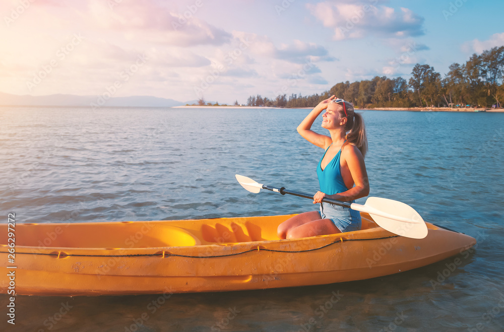 Girl  on kayak  sea at sunset, healthy lifestyle design. Sport, recreation Summer water sport, adventure outdoors. Tropical beach.