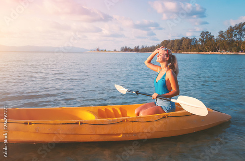 Girl on kayak sea at sunset, healthy lifestyle design. Sport, recreation Summer water sport, adventure outdoors. Tropical beach.