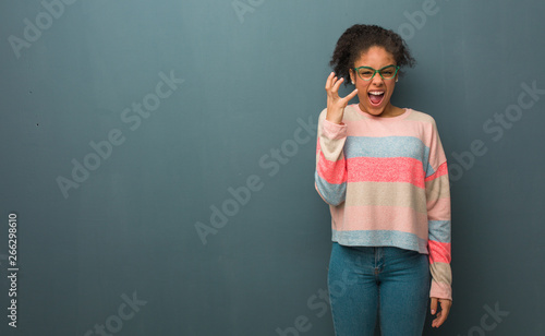 Young african american girl with blue eyes very scared and afraid