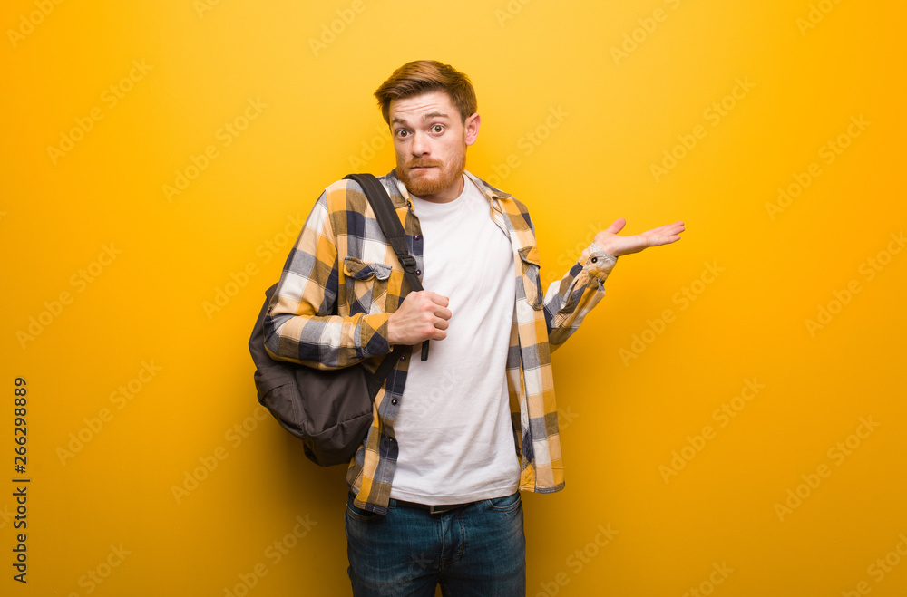 Young redhead student man confused and doubtful Young redhead student man confused and doubtful