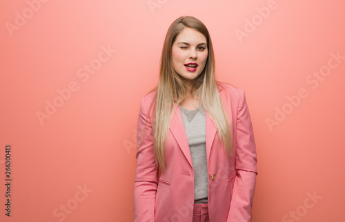 Young russian woman wearing pajama winking, funny, friendly and carefree gesture © Asier
