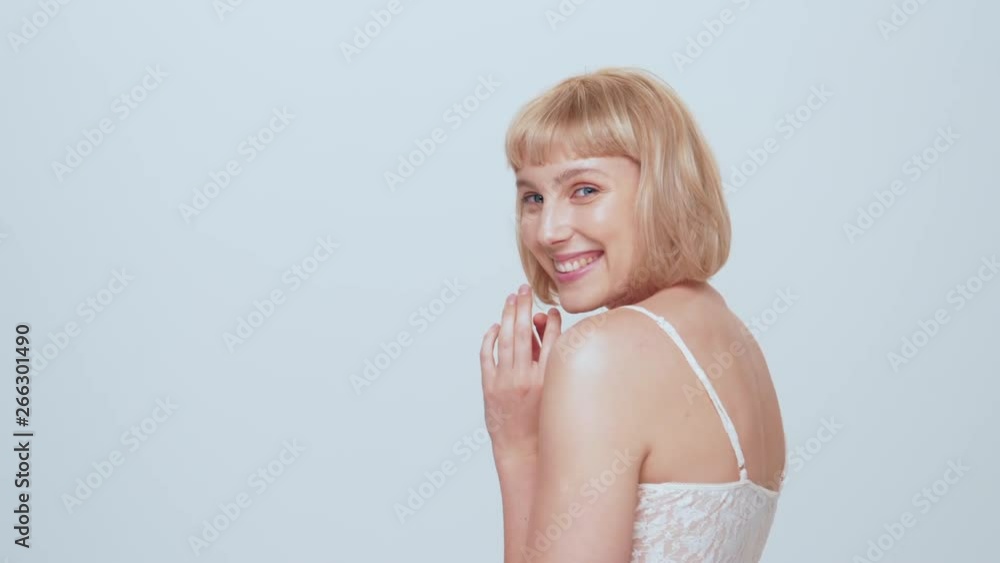 A beautiful young caucasian girl with blue eyes looks into the camera in the studio on a white background. A beautiful young caucasian girl with blue eyes looks into the camera in the studio on a white background.