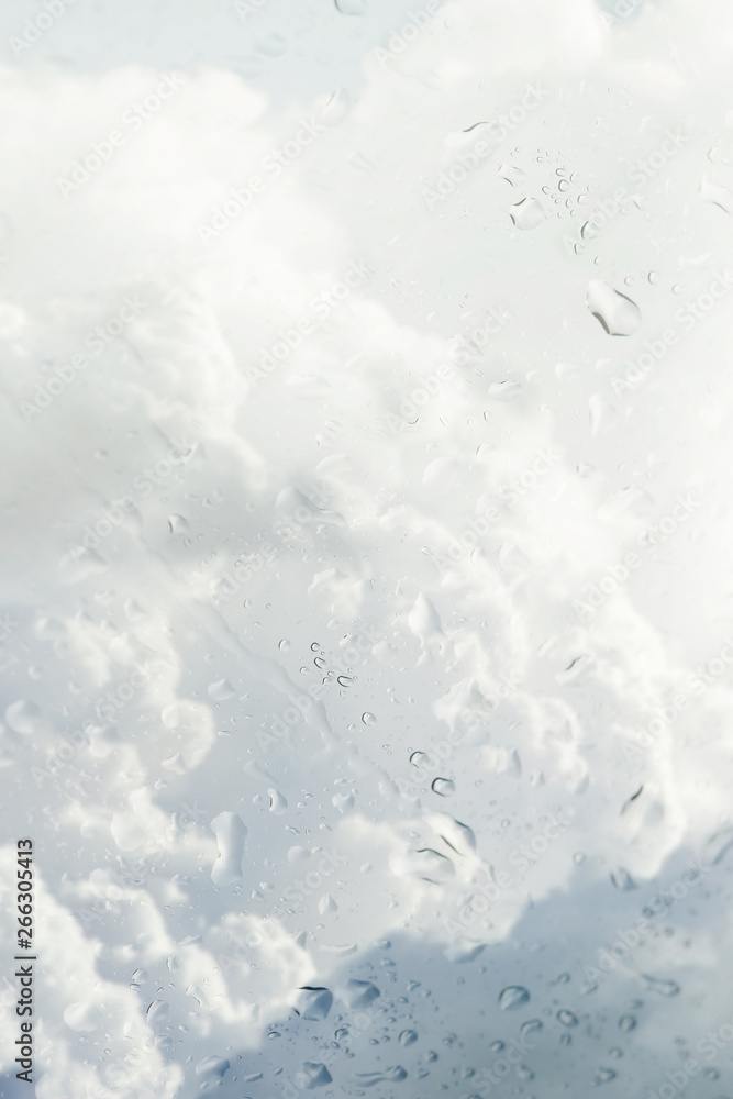 Fototapeta premium Blurry storm clouds seen through wet window on a rainy day.