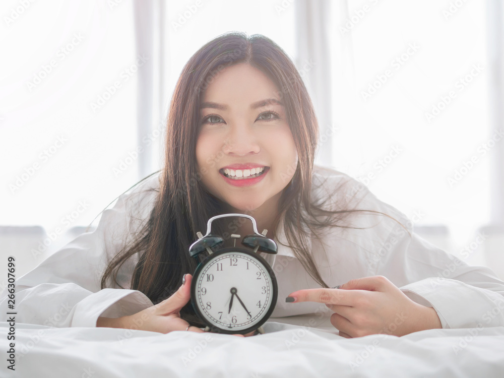 Close up of a happy young woman smile while lying on the bed at home on morning.