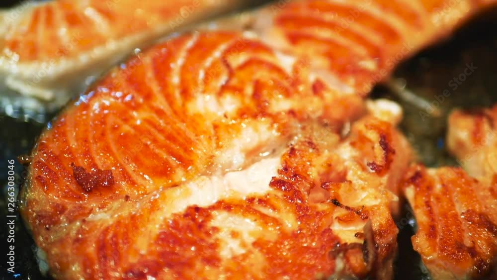 Salmon steak fillet cooking process on a frying pan. Macro shot of healthy food concept and dieting Salmon steak fillet cooking process on a frying pan. Macro shot of healthy food concept and dieting