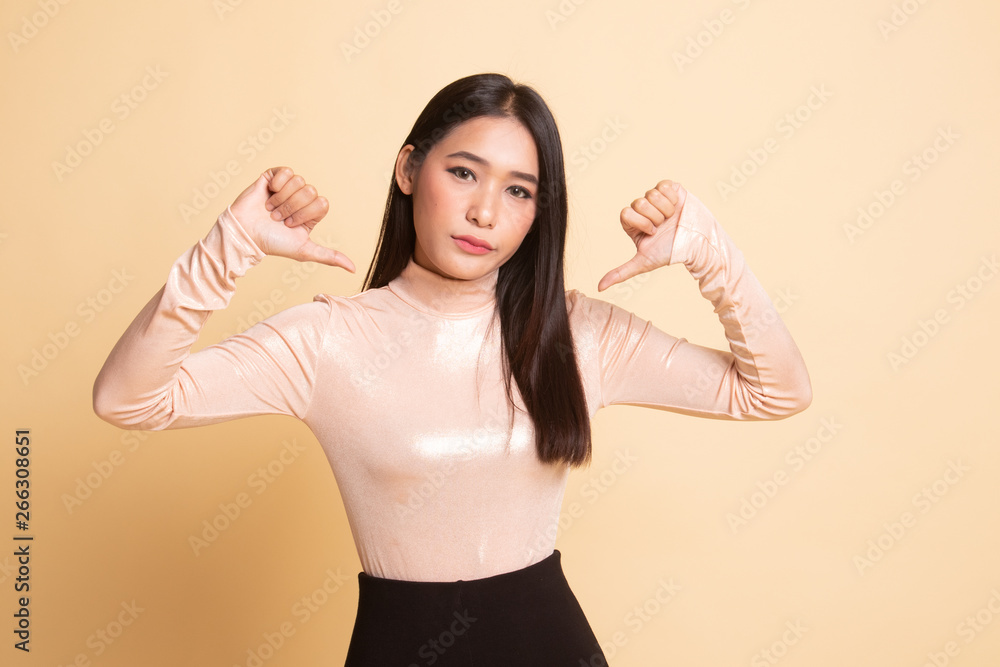 Fototapeta premium Unhappy Asian girl show thumbs down with both hands.