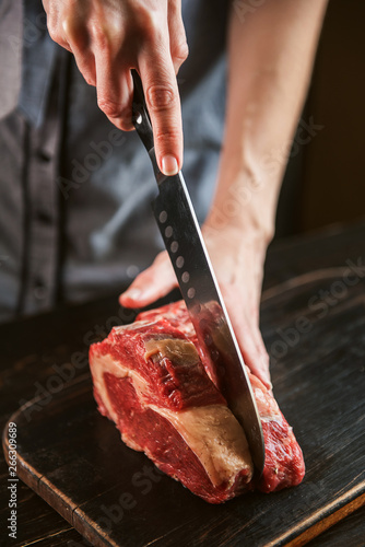 Obraz na płótnie cook cuts raw meat for steaks w salonie