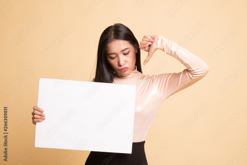 Young Asian woman show thumbs down with white blank sign. Young Asian woman show thumbs down with white blank sign.