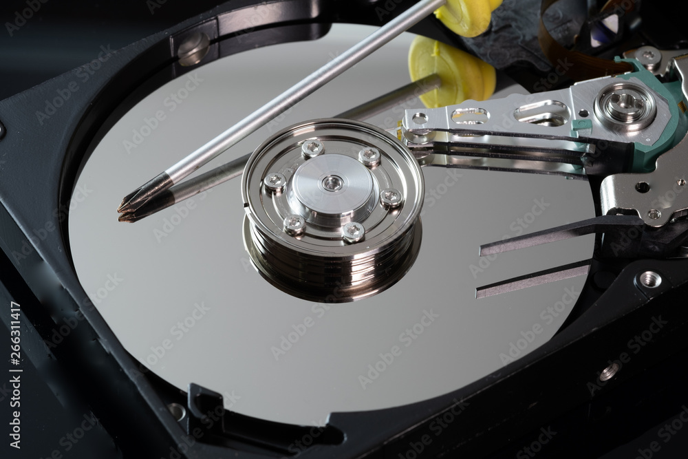 Hard drive from the computer hdd with mirror effect. Close-up, macro, on a black background. And repair tools. Hard drive from the computer hdd with mirror effect. Close-up, macro, on a black background. And repair tools.