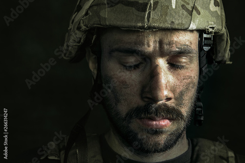 Losing sleep forever. Close up portrait of young male soldier. Man in military uniform on the war. Depressed and having problems with mental health and emotions, PTSD, rehabilitation.
