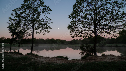 Full moon at daybreak  still waters with reflections