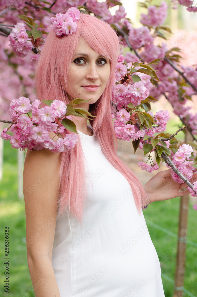 Spring woman in cherry flower bloom concept with girl sakura. Pregnant woman Spring woman in cherry flower bloom concept with girl sakura. Pregnant woman