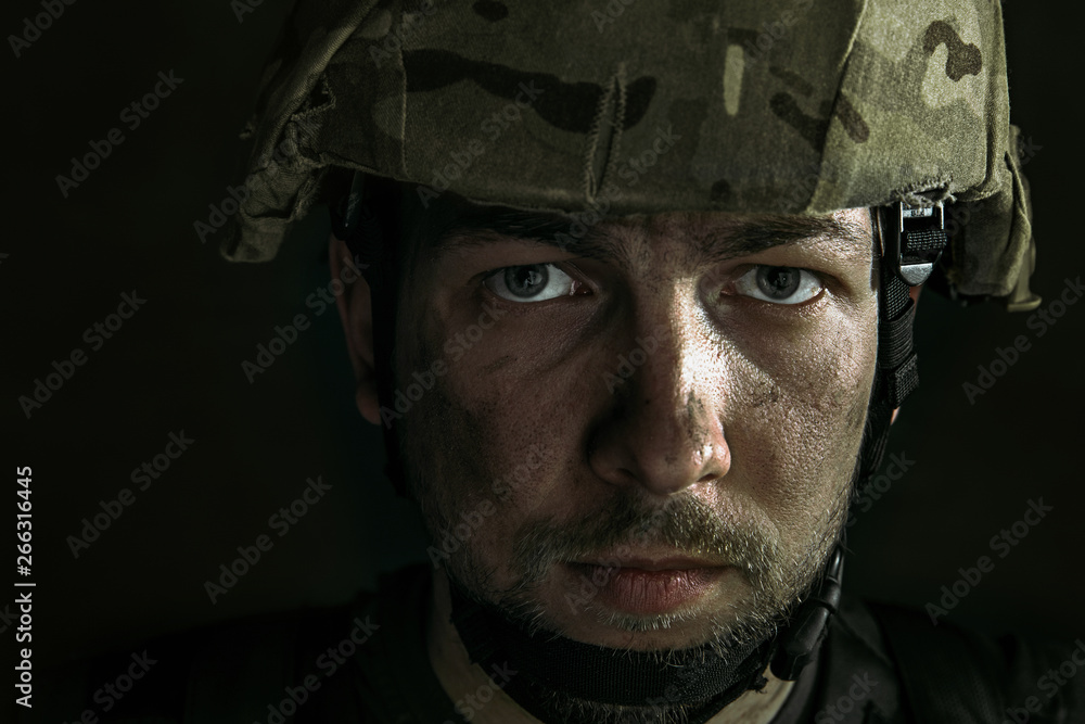 Endless war inside me. Close up portrait of young male soldier. Man in military uniform on the war. Depressed and having problems with mental health and emotions, PTSD, rehabilitation. Endless war inside me. Close up portrait of young male soldier. Man in military uniform on the war. Depressed and having problems with mental health and emotions, PTSD, rehabilitation.