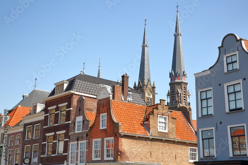 Traditional and colorful facades on the main square (Markt) with the spires of Maria van Jesse Kerk in the background, Delft, Netherlands