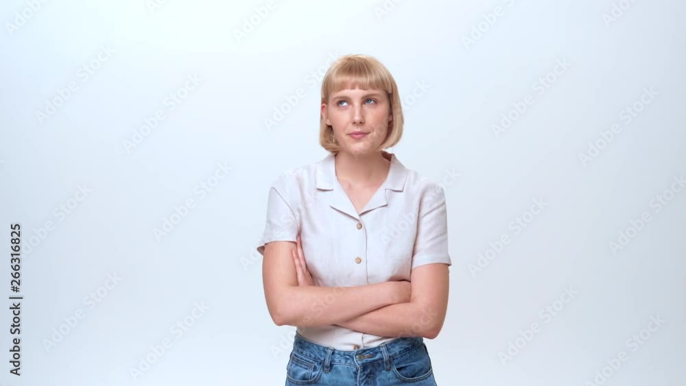 A young woman with blue eyes and blonde hair is rolling her eyes and showing the emotion of being fed up and not being interested to solve a problem. A young woman with blue eyes and blonde hair is rolling her eyes and showing the emotion of being fed up and not being interested to solve a problem.