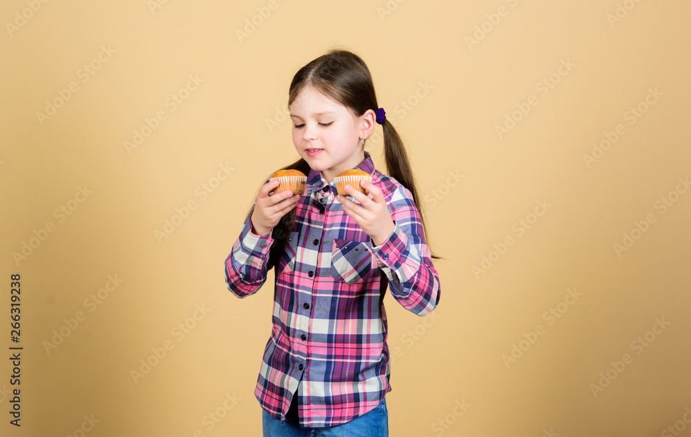 Baking freshness every day. Cute small child enjoy baking and eating sweet food. Adorable little girl holding freshly baked cupcakes. Following the best baking recipe. Home baking Baking freshness every day. Cute small child enjoy baking and eating sweet food. Adorable little girl holding freshly baked cupcakes. Following the best baking recipe. Home baking