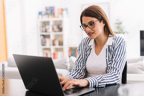 Businesswoman using laptop and drinking coffee