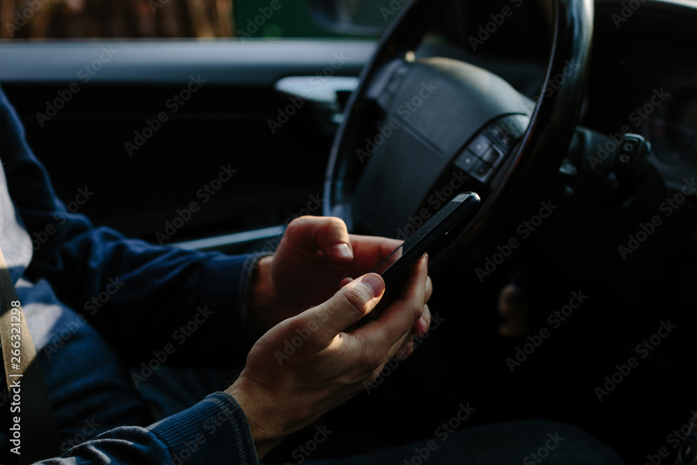 man sits in the car looks into the phone man sits in the car looks into the phone