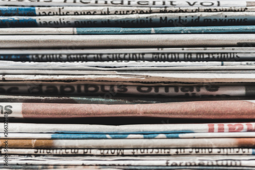 close up of different print daily newspapers in pile