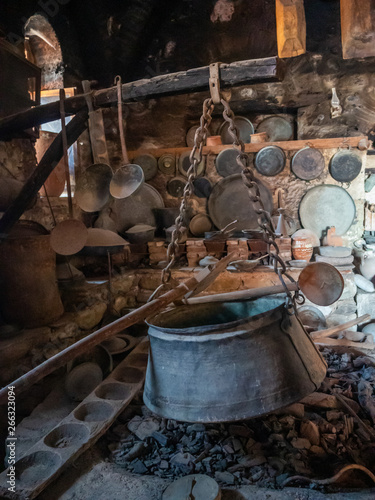 Ancient utensils and hearth with a boiler in the ancient kitchen in the Megala Meteora monastery in Meteora region, Greece