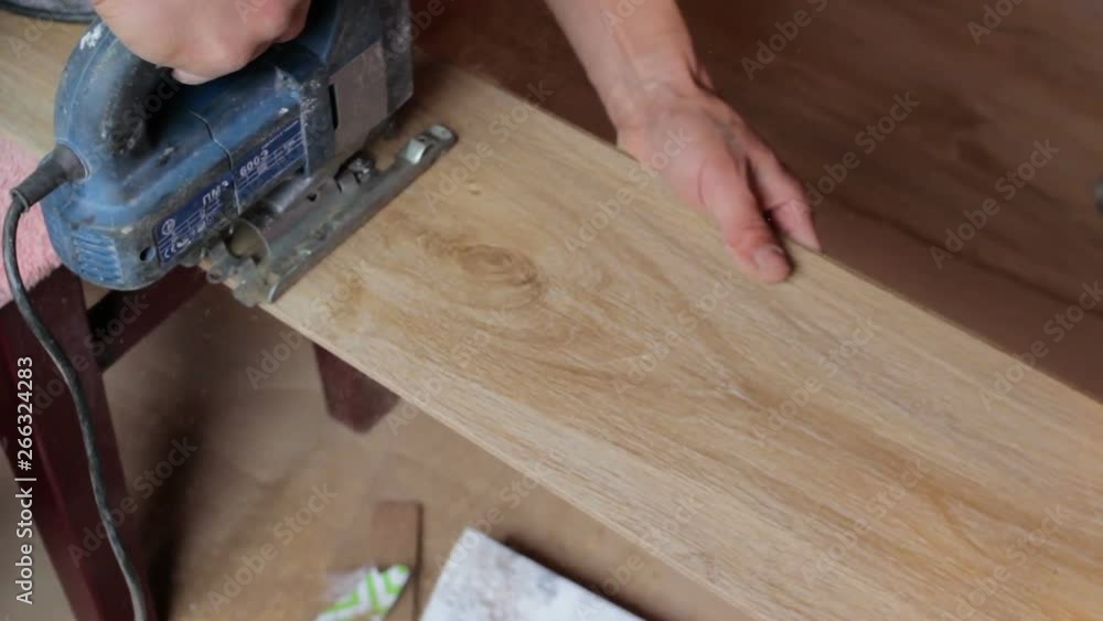 Jigsaw Cutting the Laminate,A man in the room is cutting a laminate