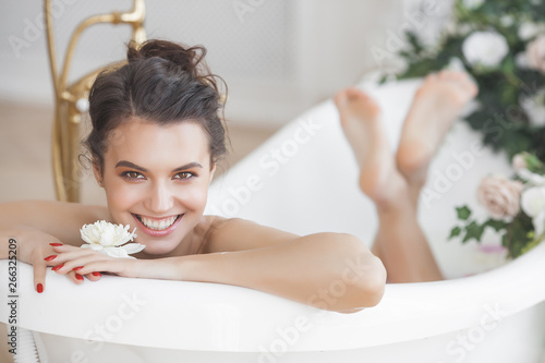 Perfact woman bathing with flowers and milk