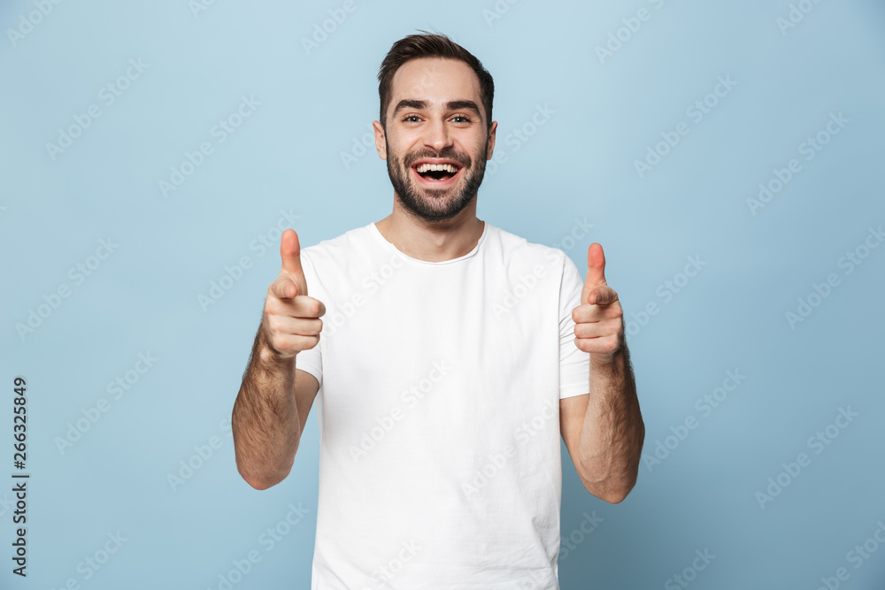 Cheerful excited man wearing blank t-shirt standing - obrazy, fototapety, plakaty 