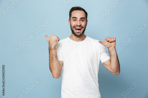 Cheerful excited man wearing blank t-shirt standing