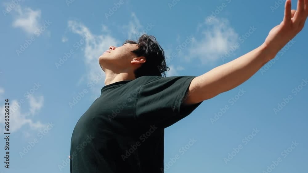Man relaxing on the freedom with raised hands over blue sky background Man relaxing on the freedom with raised hands over blue sky background