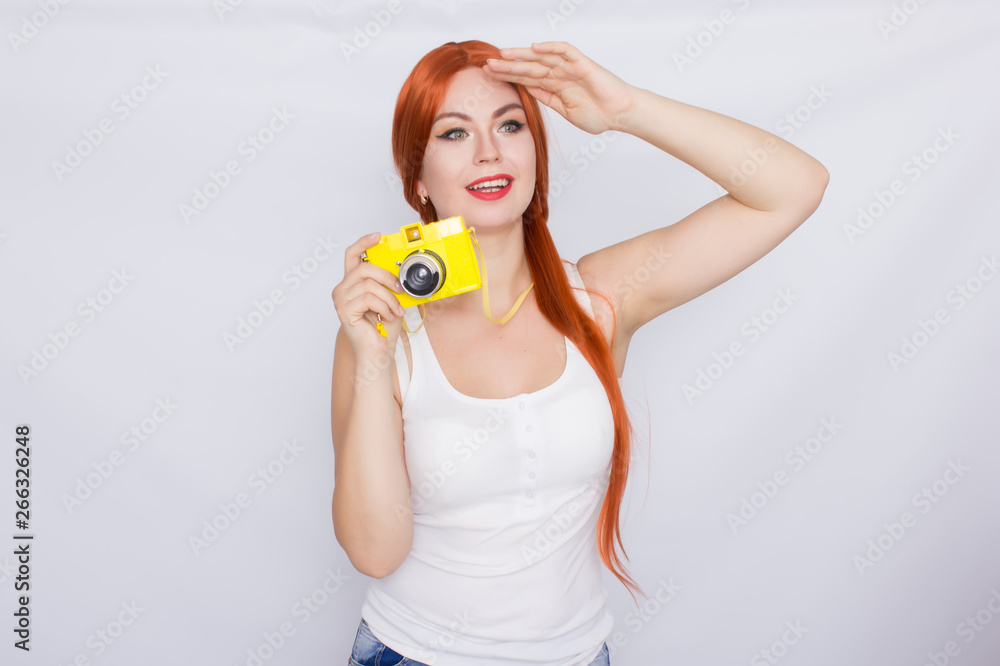 Redhead woman making photot and looking at yellow camera Redhead woman making photot and looking at yellow camera