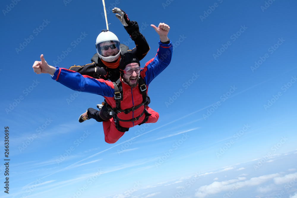 Tandem skydiving. Two happy men are in the sky.