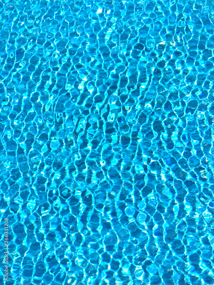 Azure ripples and shapes of water made on the surface of a swimming pool, suitable for a background. 