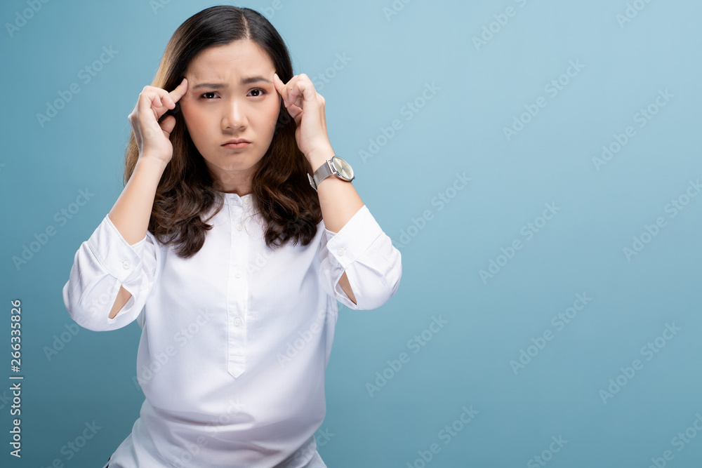 Woman has headache isolated over blue background Woman has headache isolated over blue background