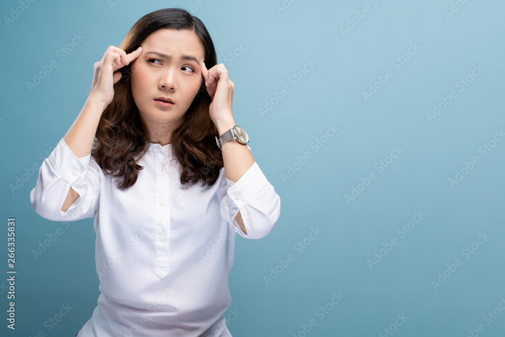 Woman has headache isolated over blue background Woman has headache isolated over blue background
