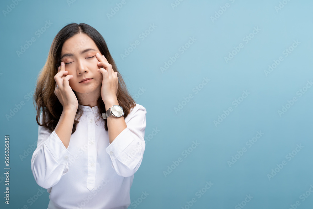 Woman has eyes pain isolated over blue background Woman has eyes pain isolated over blue background