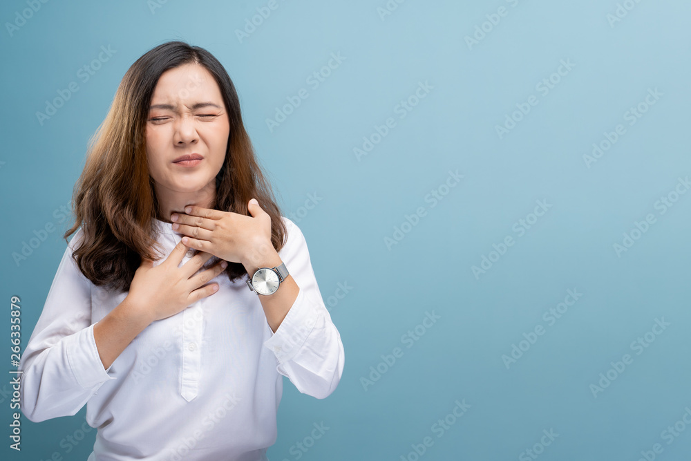 Woman has sore throat isolated over blue background