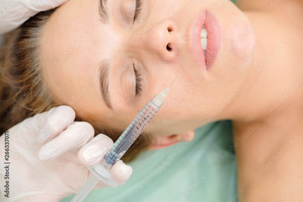 Cosmetologist making mesotherapy injection. Syringe and needle injecting botox. Female patient, woman is getting botox procedure at beautician. Hardware cosmetology, face rejuvenation. Close up Cosmetologist making mesotherapy injection. Syringe and needle injecting botox. Female patient, woman is getting botox procedure at beautician. Hardware cosmetology, face rejuvenation. Close up