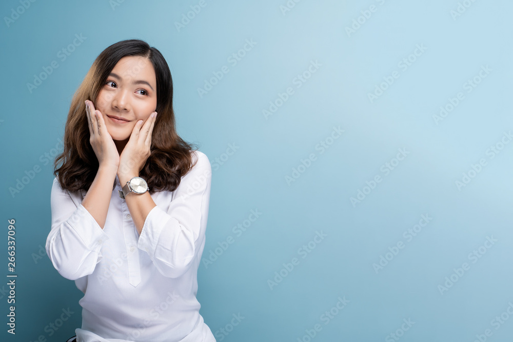 Happy woman thinking and standing isolated over blue background Happy woman thinking and standing isolated over blue background