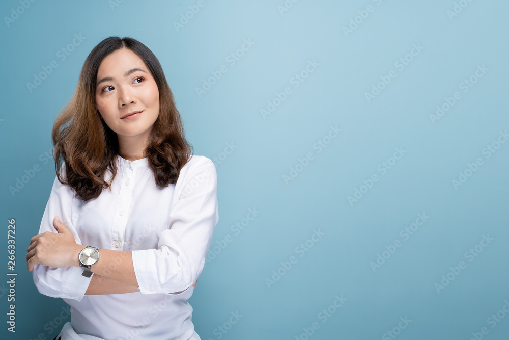 Happy woman thinking and standing isolated over blue background Happy woman thinking and standing isolated over blue background