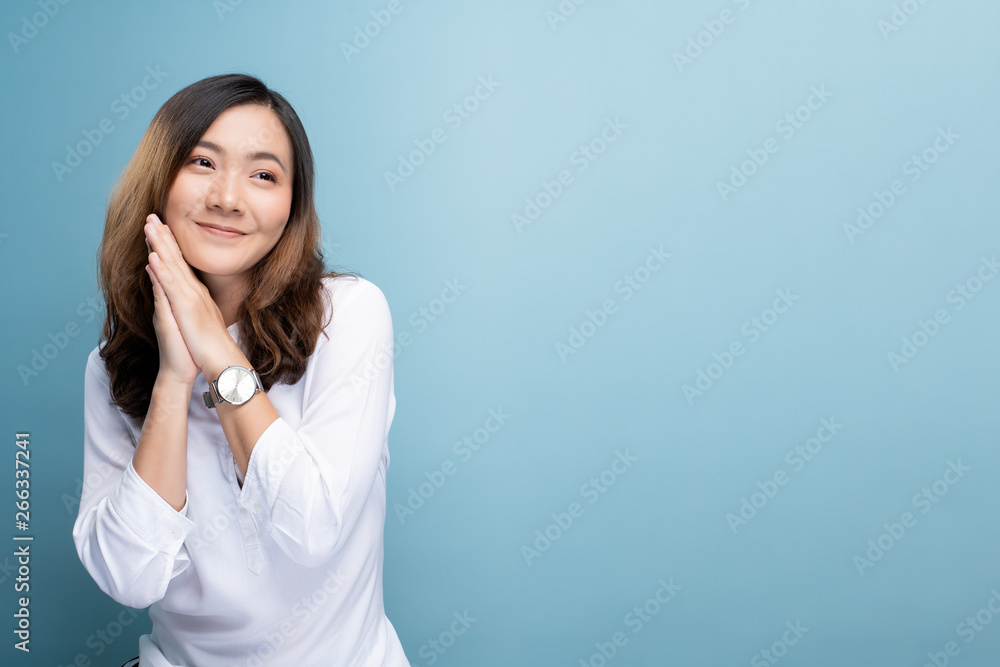 Happy woman thinking and standing isolated over blue background Happy woman thinking and standing isolated over blue background