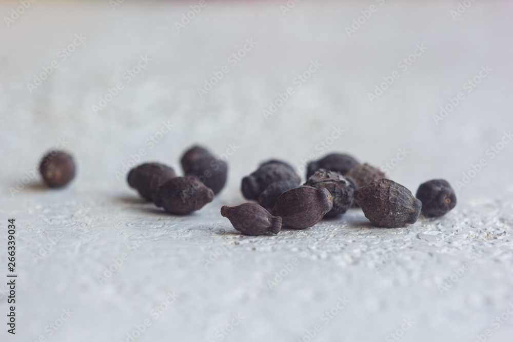 Obraz premium A heap of dried black flower seeds close-up on a white table background. planting season. close up top view copy space