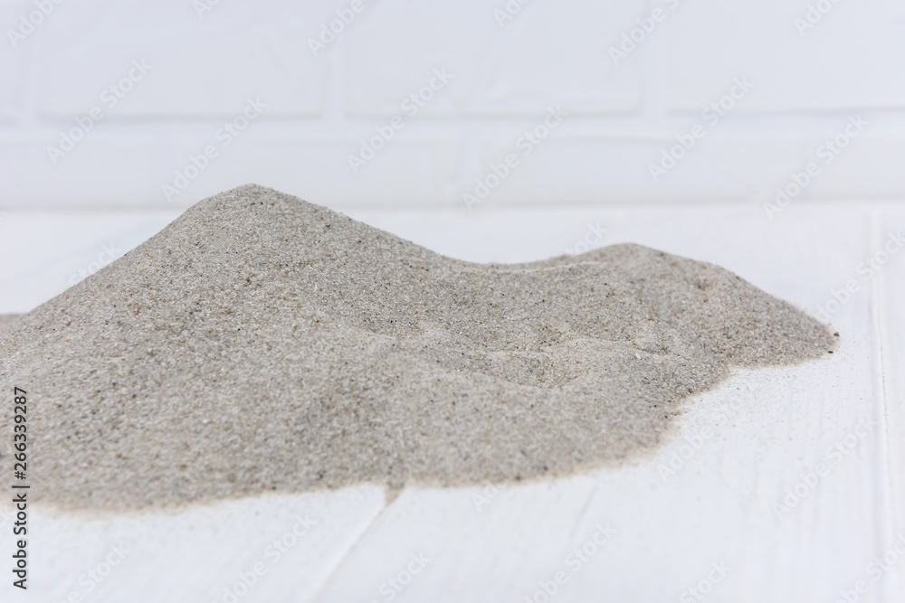 Fototapeta premium Sand on light wooden background close up
