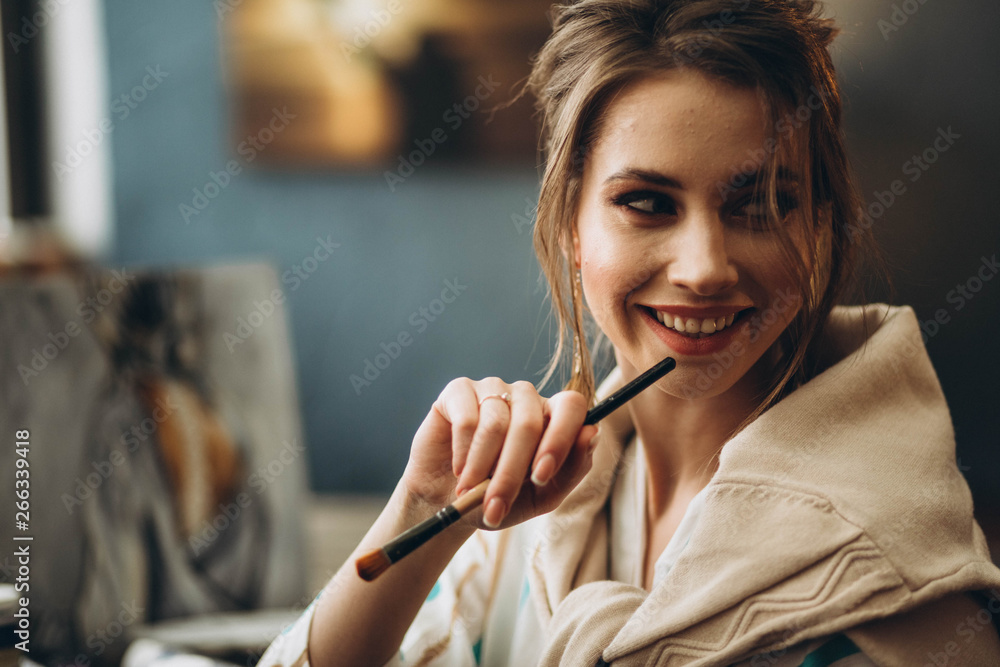 beautiful young girl holding brushes for drawing