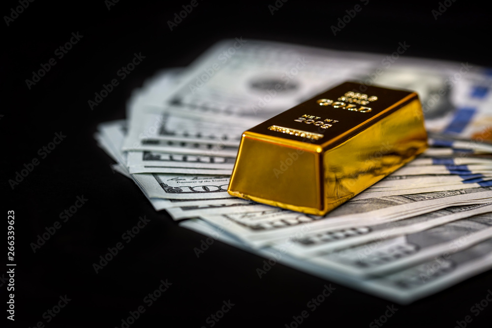 Dollar banknotes on black background with gold bullion Dollar banknotes on black background with gold bullion
