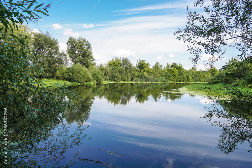 Beautiful summer landscape with pretty river and colorful trees. View of the sky with beautiful clouds. Stock photo Beautiful summer landscape with pretty river and colorful trees. View of the sky with beautiful clouds. Stock photo