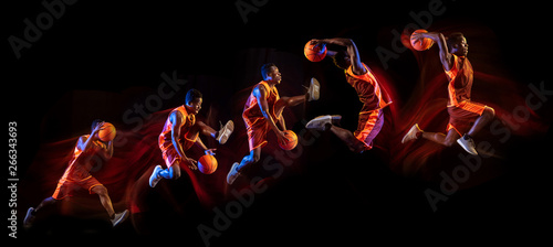 Fire tail or ways. African-american young basketball player of red team in action and neon lights over dark studio background. Concept of sport, movement, energy and dynamic, healthy lifestyle. © master1305